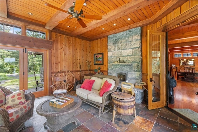 living room featuring ceiling fan, wooden ceiling, and wooden walls