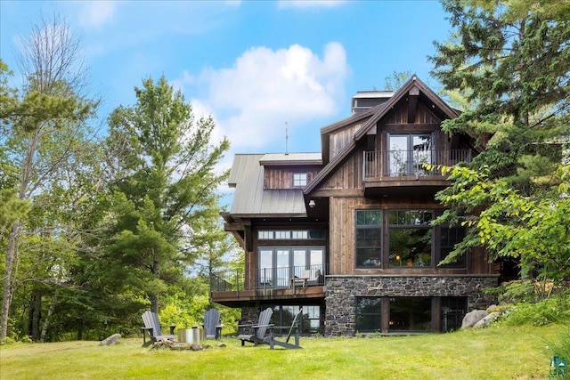 rear view of property with a lawn and a balcony