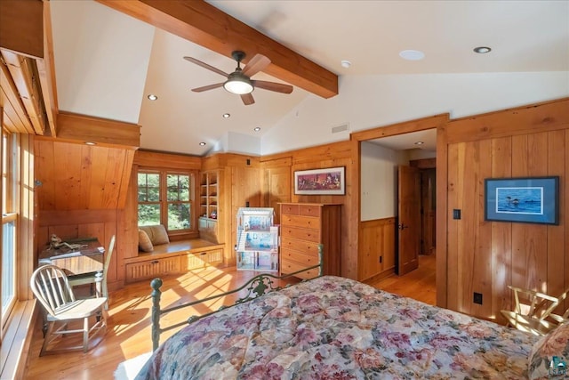 bedroom with ceiling fan, lofted ceiling with beams, light wood-type flooring, and wooden walls