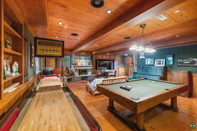 playroom featuring built in shelves, a stone fireplace, beamed ceiling, light hardwood / wood-style floors, and billiards