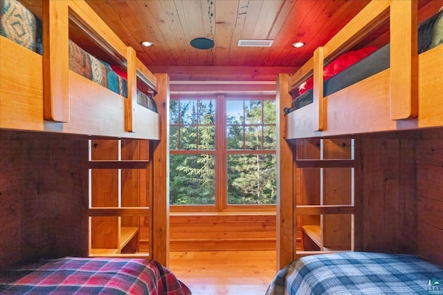 bedroom with wooden walls and wooden ceiling