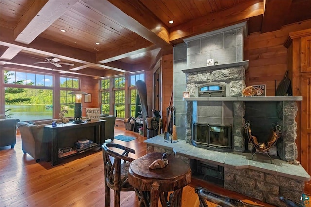 living room featuring ceiling fan, a healthy amount of sunlight, beamed ceiling, and hardwood / wood-style floors