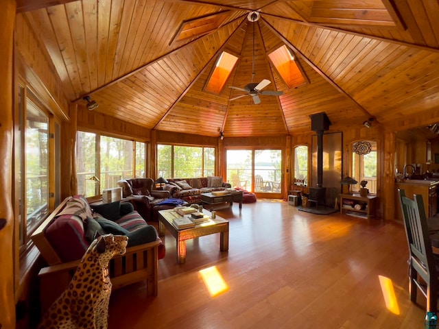 living room with wooden ceiling, hardwood / wood-style flooring, a wood stove, high vaulted ceiling, and ceiling fan