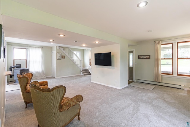 living room with a baseboard heating unit and light colored carpet