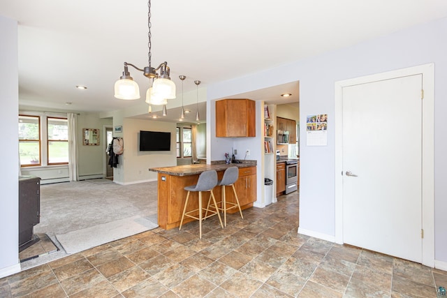 kitchen with decorative light fixtures, a baseboard radiator, a kitchen breakfast bar, kitchen peninsula, and stainless steel appliances