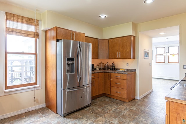 kitchen with an inviting chandelier, stainless steel fridge, and hanging light fixtures