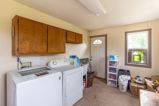 laundry area featuring cabinets, separate washer and dryer, and light carpet