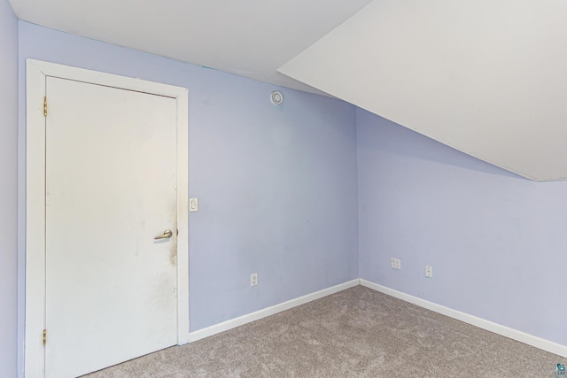 bonus room featuring vaulted ceiling and light carpet