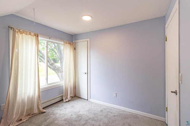 carpeted spare room featuring plenty of natural light, a baseboard radiator, and vaulted ceiling