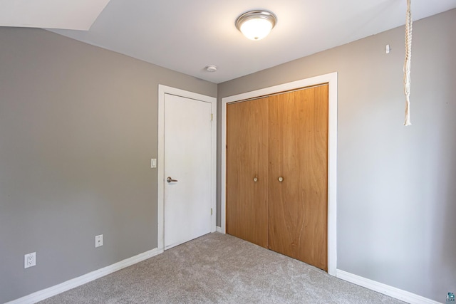 unfurnished bedroom featuring carpet flooring and a closet