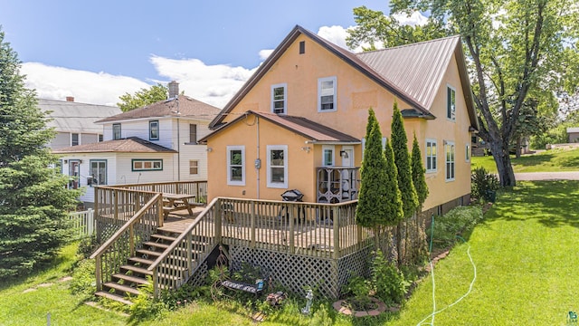 rear view of house with a deck and a lawn