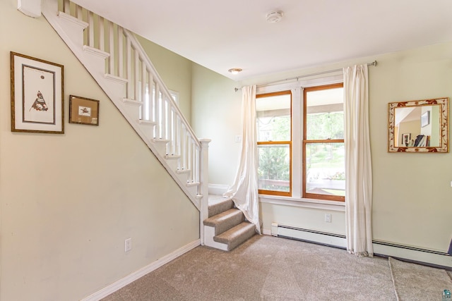 stairway with a baseboard radiator and carpet