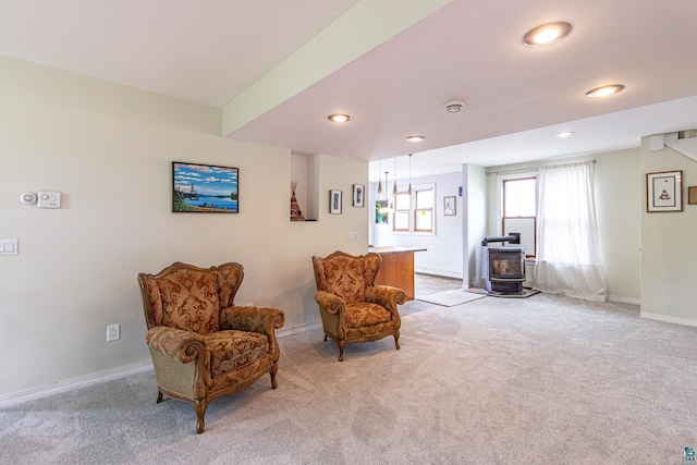 living area featuring a wood stove and light colored carpet