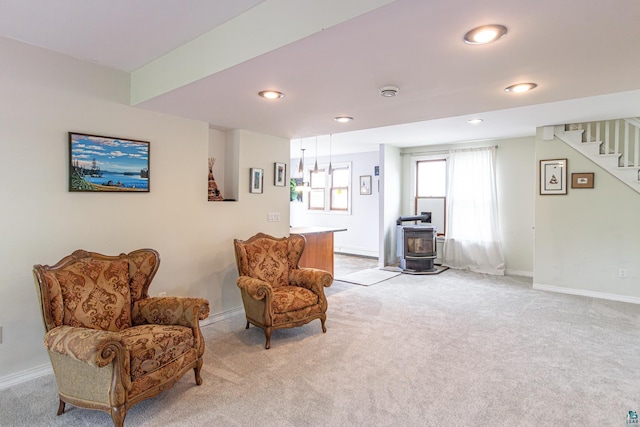 living area with a wood stove and light carpet