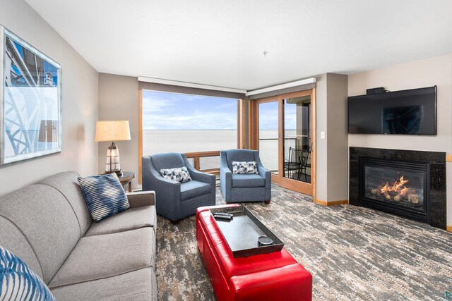 living room featuring a water view and dark carpet