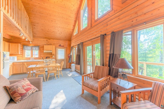 carpeted living room featuring log walls, sink, high vaulted ceiling, and wooden ceiling