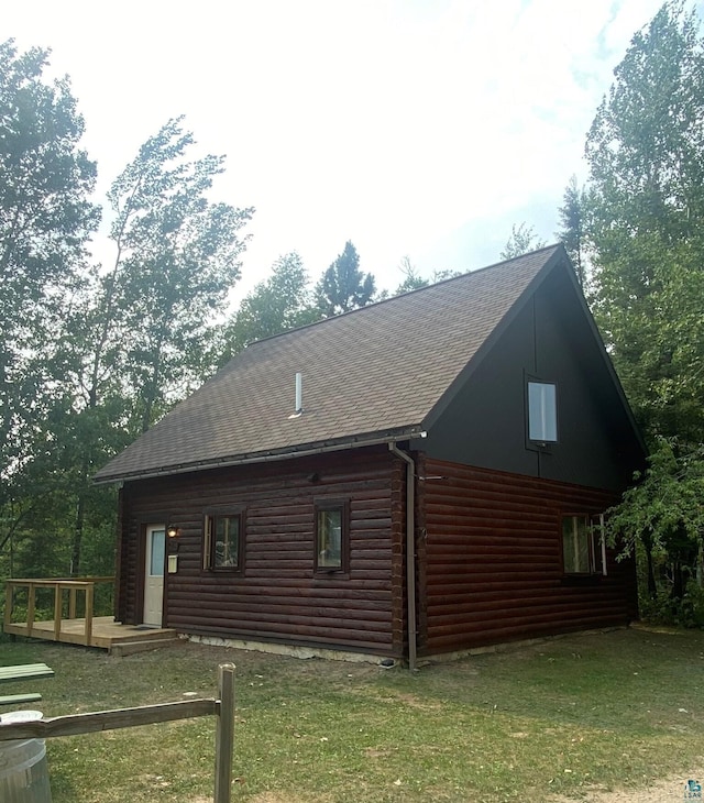 view of side of home with a yard and a wooden deck