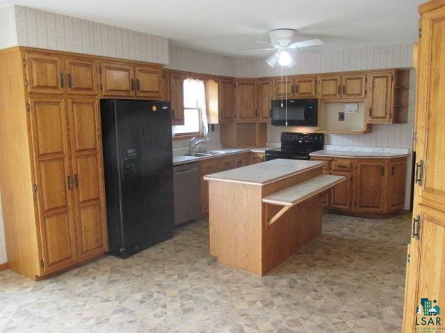 kitchen with a center island, sink, black appliances, and ceiling fan