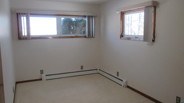 carpeted spare room featuring a baseboard radiator