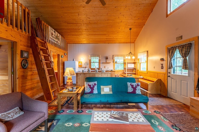 living room with ceiling fan with notable chandelier, wood walls, wooden ceiling, wood-type flooring, and high vaulted ceiling