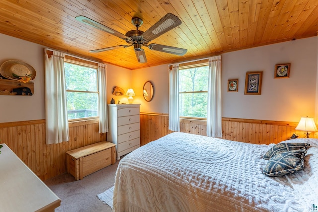 296 Shady Ln, Ely, MN 55731 - carpeted bedroom with wood walls, wainscoting, wood ceiling, and ceiling fan