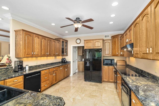 kitchen featuring visible vents, ornamental molding, dark stone counters, under cabinet range hood, and black appliances