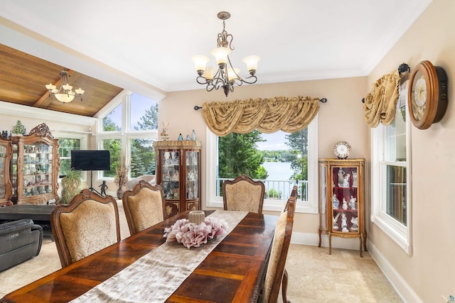 dining room with crown molding, baseboards, and a notable chandelier