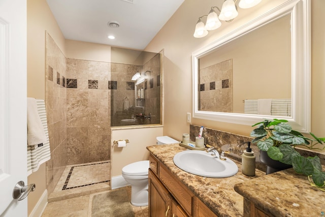 bathroom with visible vents, toilet, vanity, a walk in shower, and tile patterned flooring