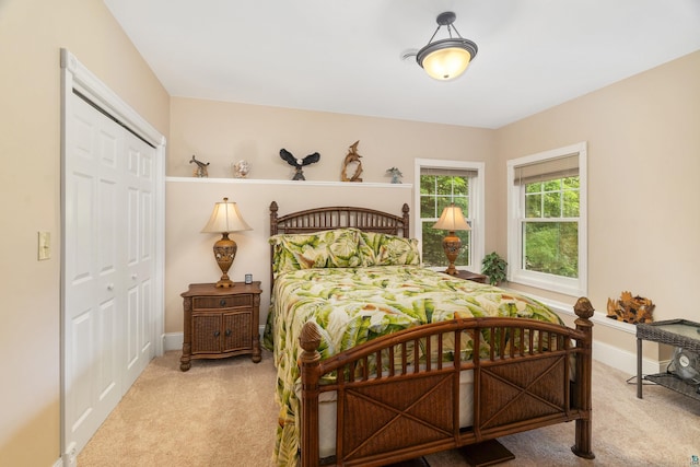 carpeted bedroom with a closet and baseboards