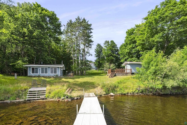 dock area featuring a lawn and a deck with water view