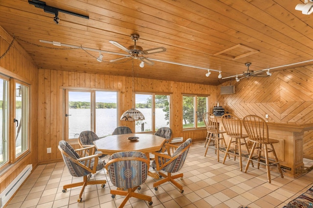 dining room featuring a water view, wood walls, a baseboard radiator, and wood ceiling