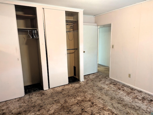 unfurnished bedroom featuring two closets and carpet