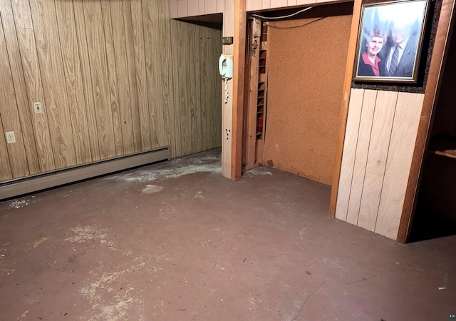 basement with wood walls and baseboard heating