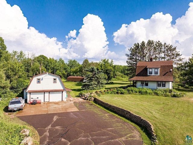 view of front of house with an outdoor structure, a garage, and a front yard