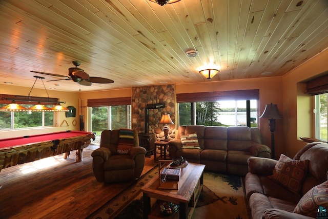 living room with hardwood / wood-style floors, ceiling fan, wooden ceiling, pool table, and a wood stove