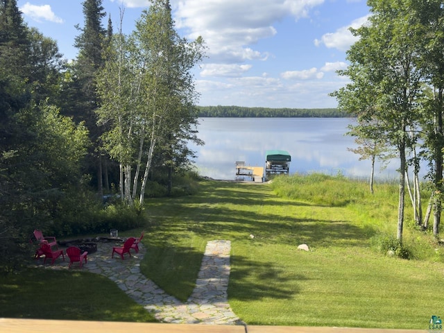 view of yard featuring a water view and a boat dock