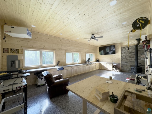 living room featuring wooden walls, a wood stove, electric panel, and wooden ceiling