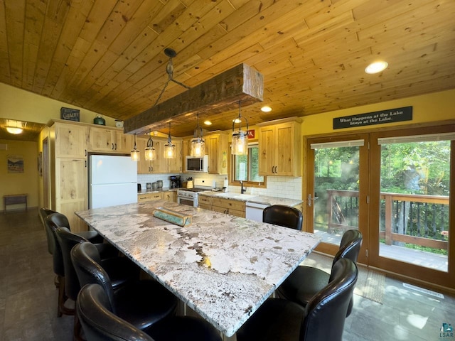 kitchen with stainless steel appliances, vaulted ceiling, hanging light fixtures, and a center island