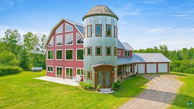 view of front of house with dirt driveway, french doors, metal roof, a front yard, and a garage