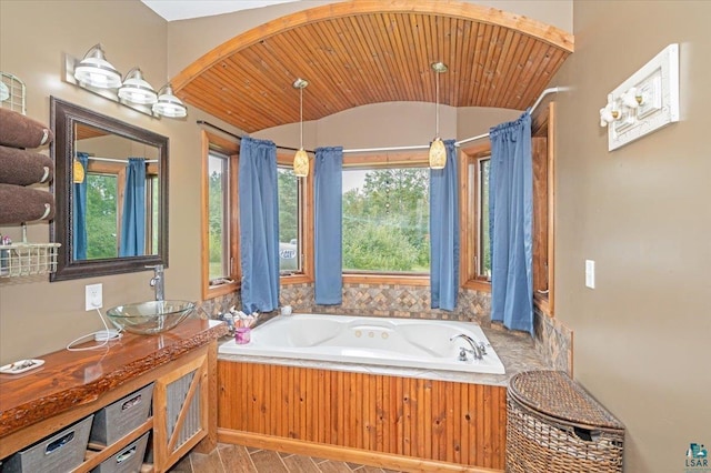 bathroom with tile patterned floors, wood ceiling, vanity, and a bathtub