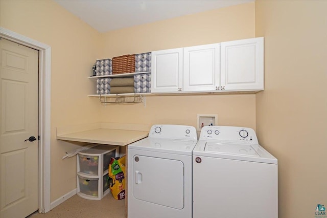 washroom featuring washing machine and clothes dryer and cabinets