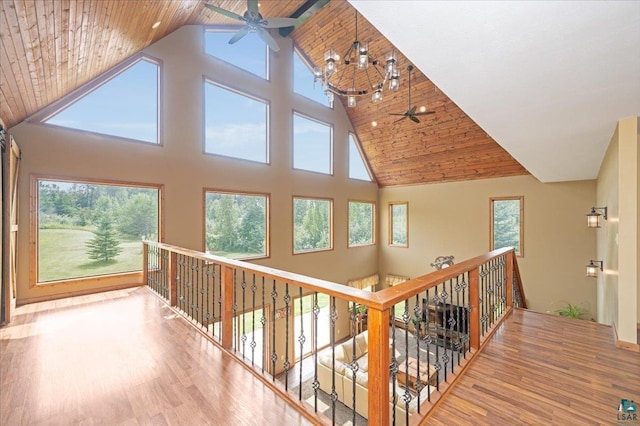 hallway with a healthy amount of sunlight, high vaulted ceiling, and wooden ceiling