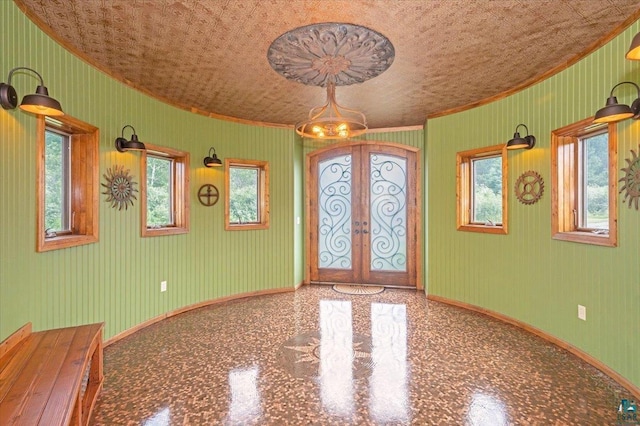 unfurnished room featuring french doors, crown molding, and baseboards