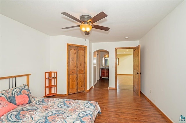 bedroom with connected bathroom, hardwood / wood-style floors, and ceiling fan