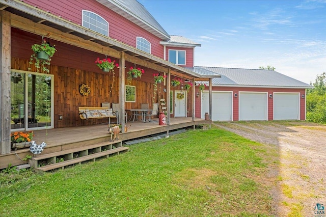 exterior space featuring a garage, a wooden deck, and a front yard