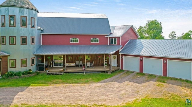 exterior space featuring covered porch, a garage, and a front lawn