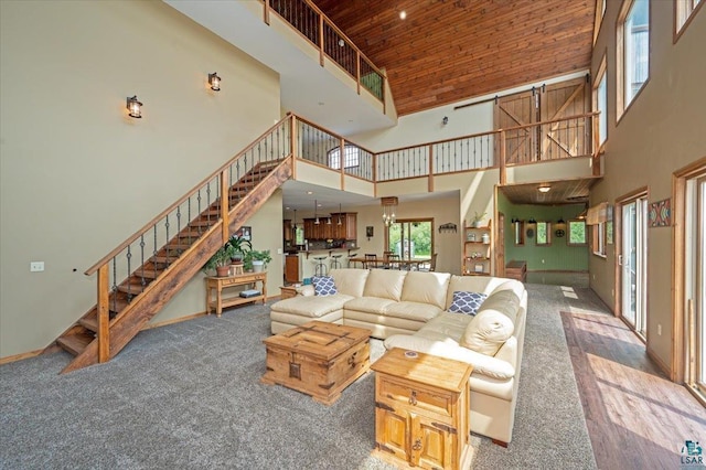 living room with carpet flooring, a towering ceiling, and wood ceiling