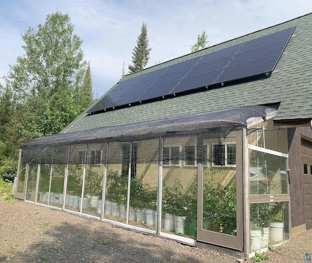 exterior space with solar panels and a sunroom