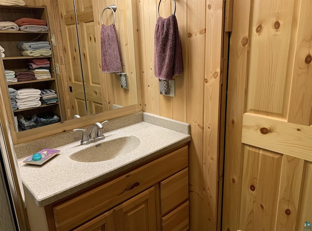 bathroom with wood walls and vanity