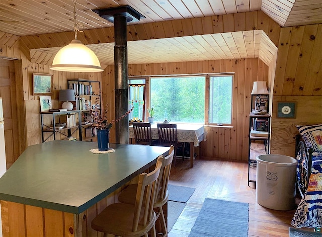 dining space with wood ceiling, light hardwood / wood-style flooring, and wooden walls